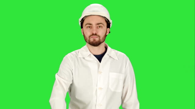 Man-in-the-construction-helmet-with-a-raised-finger-on-a-Green-Screen,-Chroma-Key
