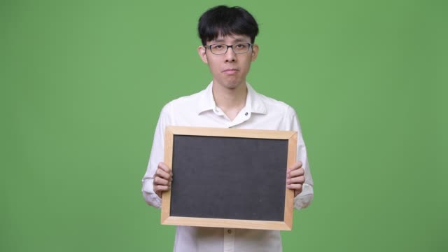 Young-Asian-businessman-holding-blackboard