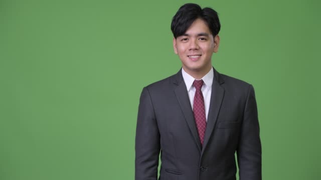 Joven-guapo-empresario-asiático-mostrando-algo
