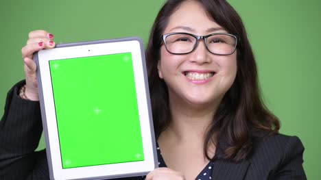 Reife-schöne-asiatische-geschäftsfrau-zeigt-digital-Tablette