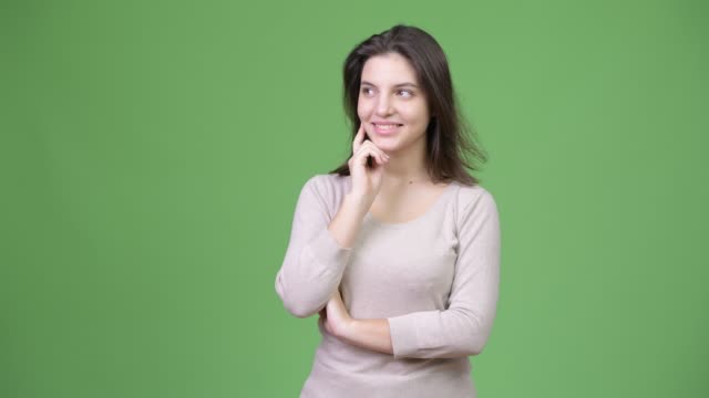 Junge-glücklich-schöne-Frau-vor-grünem-Hintergrund-denken