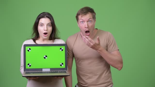Young-couple-showing-laptop-while-looking-shocked-together