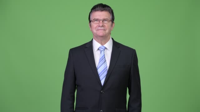 Senior-gut-aussehend-Geschäftsmann-vor-grünem-Hintergrund