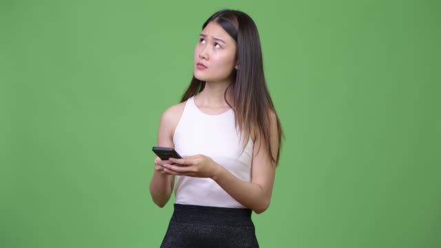 Young-beautiful-Asian-businesswoman-using-phone
