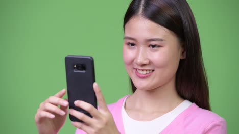 Junge-schöne-asiatische-Frau-mit-Telefon