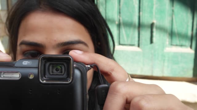 Indische-städtische-Tourist-junge-Frau-nimmt-Fotos-Videos-auf-ihr-point-and-shoot-Kamera-auf-den-Straßen-beschäftigt-corwded