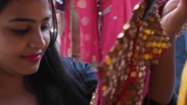 Indische-städtische-Tourist-junge-Frau-einkaufen-und-mit-Blick-auf-traditionelle-ethnische-Bekleidung-in-einem-Geschäft