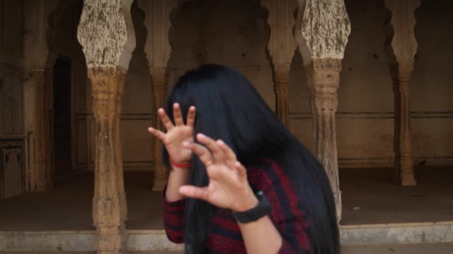 Beautiful-young-lady-looking-at-camera-POV-gets-scared-afraid-shocked-disgust-sudden-fun-around-mid-shot-handheld-looking-at-camera-for-demon-shock-joke-kidding-play-games-at-a-sacred-temple-complex