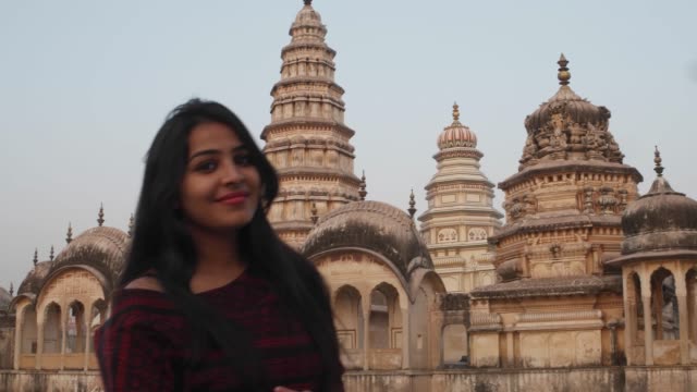 Woman-in-front-of-panoramic-attractive-ornate-temple-fort-palace-complex-from-a-vantage-point-higher-level-taking-selfie-photo-on-mobile-phone-camera-tourist--Hindu-religious-massive-love-handheld-pov