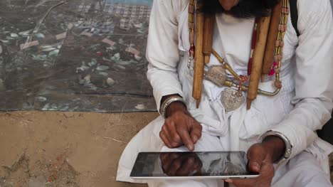 Man-being-helped-and-instructed-to-use-a-touch-screen-tablet,-Indian-Rajasthani-elderly-male-with-big-moustache-wearing-Traditional-attire-and-ethic-turban