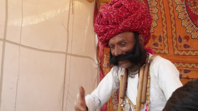 Hombre-divertido-de-Rajasthan-con-bigote-grande-bailando-con-un-chico