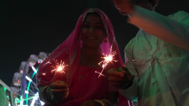 Pareja-India-en-vestido-tradicional-con-fuego-galleta-de-chispa-en-el-festival-de-Diwali-Mela-en-la-India