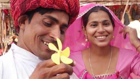 Attraktives-Rajasthani-paar-Spaß-bläst-Seifenblasen-und-tragen-ethnischen-traditionelle-indische-Kleidung-bei-Pushkar-Camel-fair,-Indien