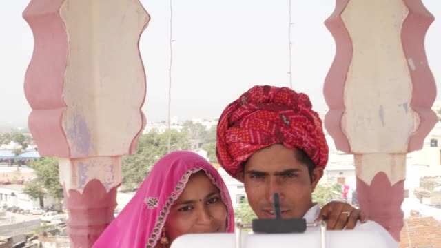 Indische-Braut-und-Bräutigam-unter-Selfies-auf-ihre-Handy-Kamera-mit-Hilfe-von-einem-Selfie-kleben-in-Rajasthan,-Indien