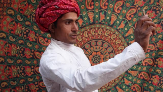 Hombre-guapo-de-Rajasthani-tomar-autorretratos-en-una-cámara-de-teléfono-celular-móvil-en-Pushkar,-India