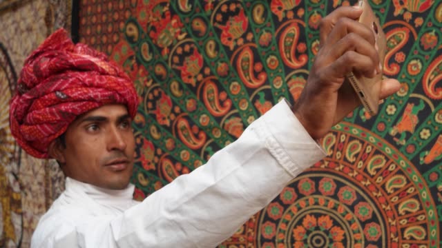 Hombre-guapo-de-Rajasthani-tomar-autorretratos-en-una-cámara-de-teléfono-celular-móvil-en-Pushkar,-India