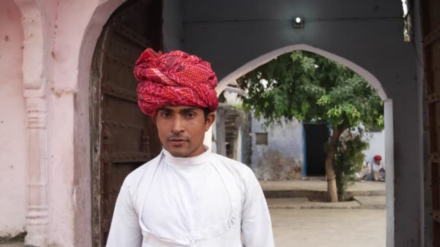 Hombre-guapo-de-Rajasthani-con-turbante-rojo-en-un-templo-de-Pushkar,-India
