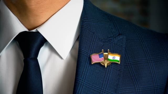 Empresario-caminando-hacia-cámara-con-amigo-país-banderas-Pin-Estados-Unidos-de-América---India.mov