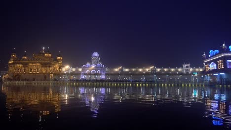 Video-de-peregrinos-sijs-en-el-templo-de-oro-al-atardecer-durante-el-día-de-la-celebración-en-diciembre-en-Amritsar,-Punjab,-India.-Harmandir-Sahib-es-el-sitio-más-sagrado-del-peregrino-para-los-Sikhs.