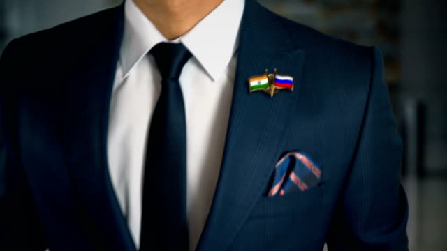 Businessman-Walking-Towards-Camera-With-Friend-Country-Flags-Pin-India---Russia