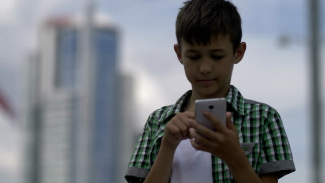 Boy-nutzt-das-Telefon,-wählt-eine-Nachricht-und-hält-in-der-Korrespondenz