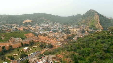 Aerial-moving-shot-of-the-small-town-or-village-surrounded-by-mountains.