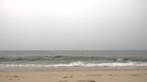 Olas-rompiendo-en-una-hermosa-playa-en-un-día-brumoso-en-Varkala,-India.