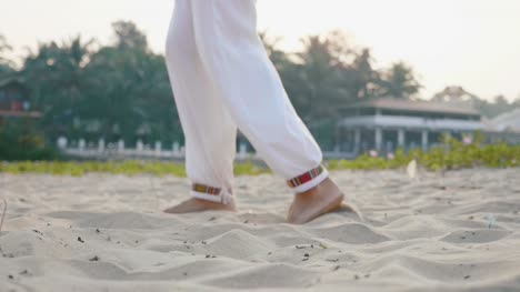 Close-up-feet-of-senior-woman-practicing-tai-chi-on-the-sand