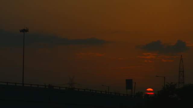 Zeitraffer-Aufnahme-von-Fahrzeugen,-die-auf-der-Brücke-in-der-Dämmerung,-Sonnenuntergang,-Delhi,-Indien