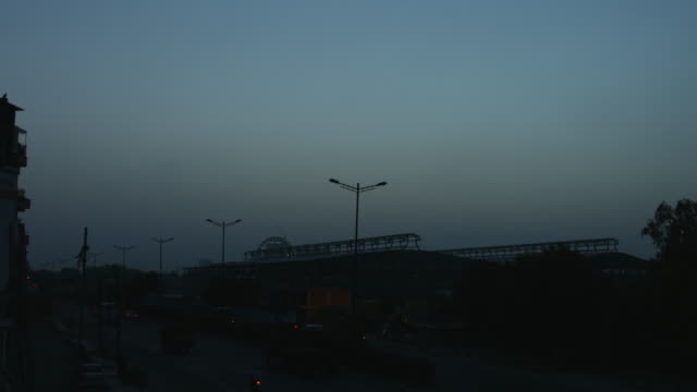 Time-lapse-shot-of-traffic-moving-on-city-street-at-dawn,-Delhi,-India