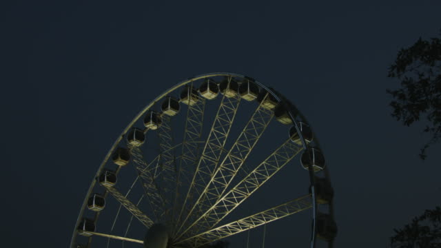 Tilt-down-shot-of-Ferris-wheel-at-night