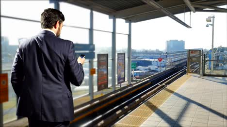 Business-Man-in-Suit-with-Mobile-Cell-Phone,-Skytrain-Subway-Station-Terminal