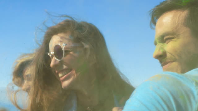 Multi-Ethnic-Group-of-Young-People-Throw-Colorful-Powder-at-Each-other-in-Celebration-of-Holi-Festival.-They-Have-Enormous-Fun-on-this-Clear-Day-by-the-Sea.