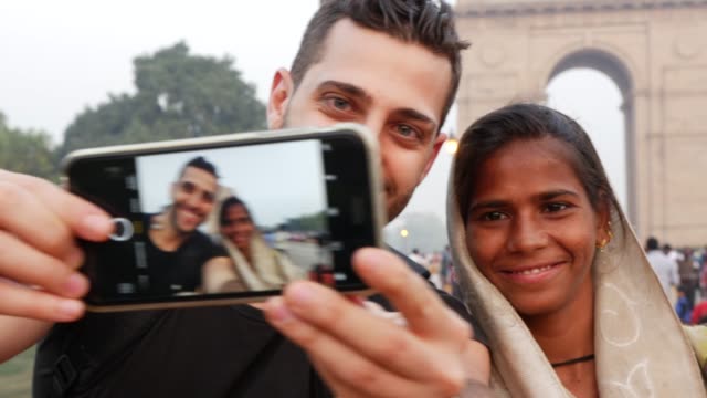 Turista-tomando-una-selfie-con-una-mujer-en-la-puerta-de-la-India,-Nueva-Delhi