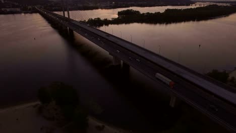 Bridge-with-trafic-over-the-river-at-sunset-aerial-drone-footage