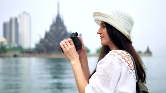 Mujer-turista-tomando-foto-del-templo-asiático