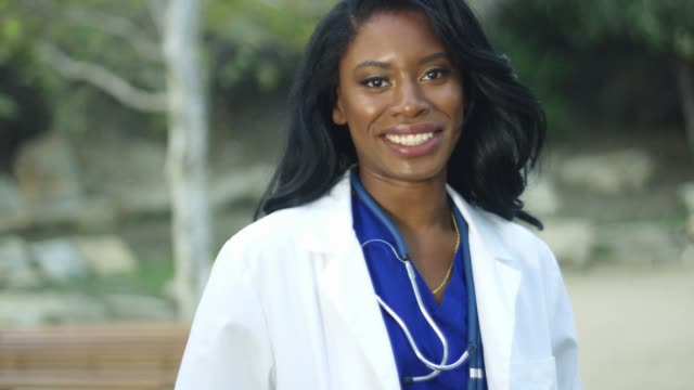 Slow-Motion-of-black-female-doctor-in-white-coat-smiling-at-the-camera