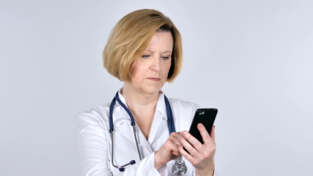 Old-Doctor-Browsing-Smartphone,-White-Background