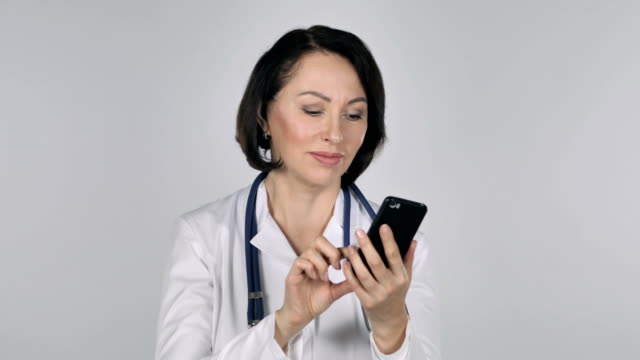 Lady-Doctor-Browsing-Smartphone,-White-Background