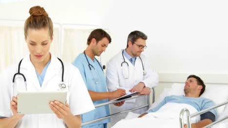 Doctors-speaking-with-sick-patient-in-bed