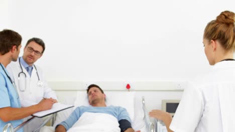 Doctors-speaking-with-sick-patient-in-bed