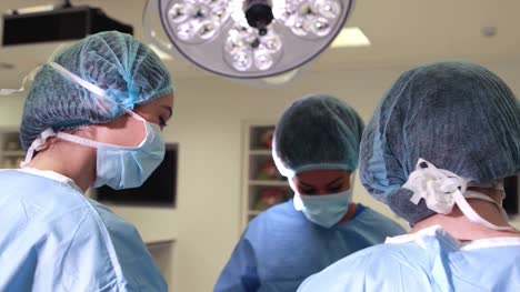 Equipo-quirúrgico-de-trabajo-juntos-en-la-operación-de-teatro