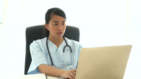 Asiatischen-Arzt-medizinische-Ergebnisse-analysieren,-am-computer-und-Notizen
