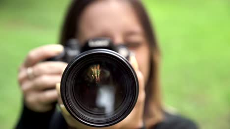 Junge-Fotografin-Frau-zeigt-das-Objektiv-an-der-Kamera
