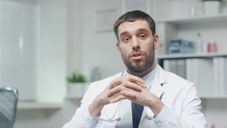 Male-Doctor-Speaks-into-the-Camera-While-Sitting-in-His-Office.