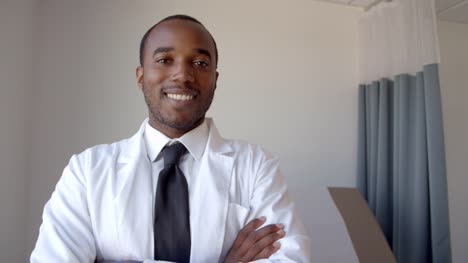 Porträt-des-männlichen-Arztes,-der-weißen-Mantel-im-Prüfungsraum-trägt