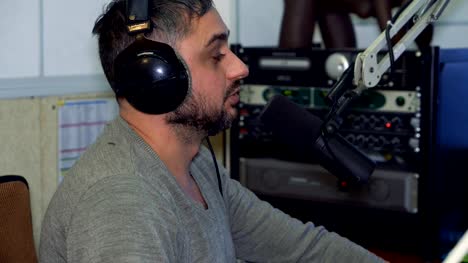 Radio-Moderator-am-Mikrofon-in-einem-live-Radio-broadcast-studio
