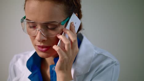 Forscherin-Frau-spricht-auf-dem-Handy.-Forscherin-in-Laborbrillen