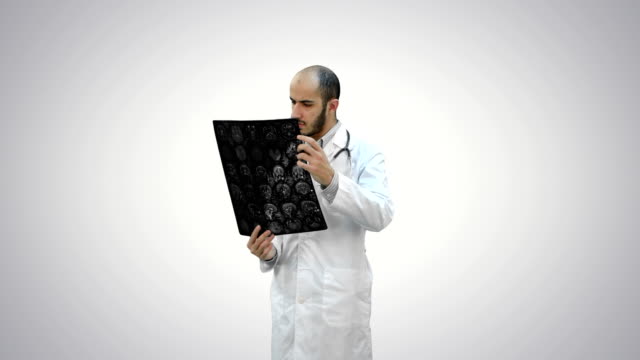 Doctor-examinando-resultados-de-Xray-sobre-fondo-blanco