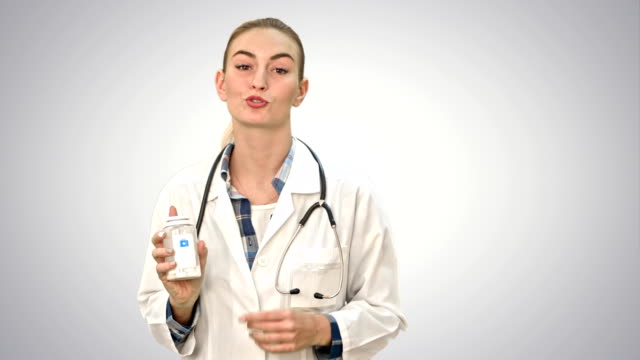 Hübschen-weiblichen-Arzt-beschreiben-und-Werbung-Pillen-für-die-Kamera-auf-weißem-Hintergrund